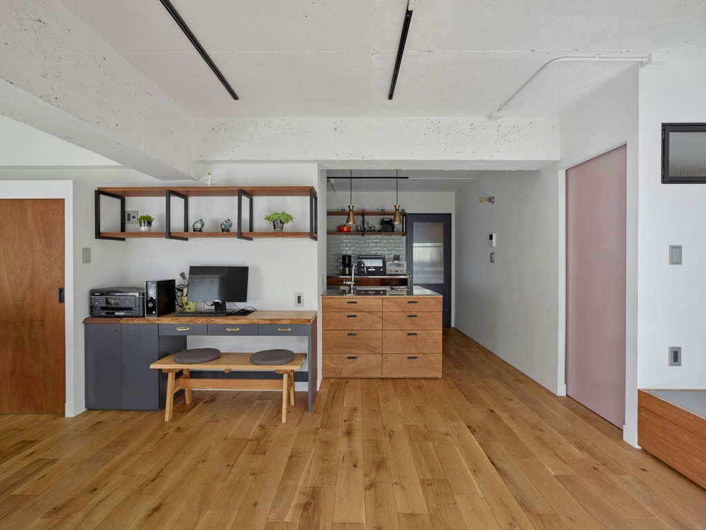 hacorenove style interior, open-plan living dining kitchen, white walls, black accents, grey sofa, walnut dining table, marble kitchen island, oak flooring, brass pendant lights, modern minimalist, neutral tones, soft ambient lighting