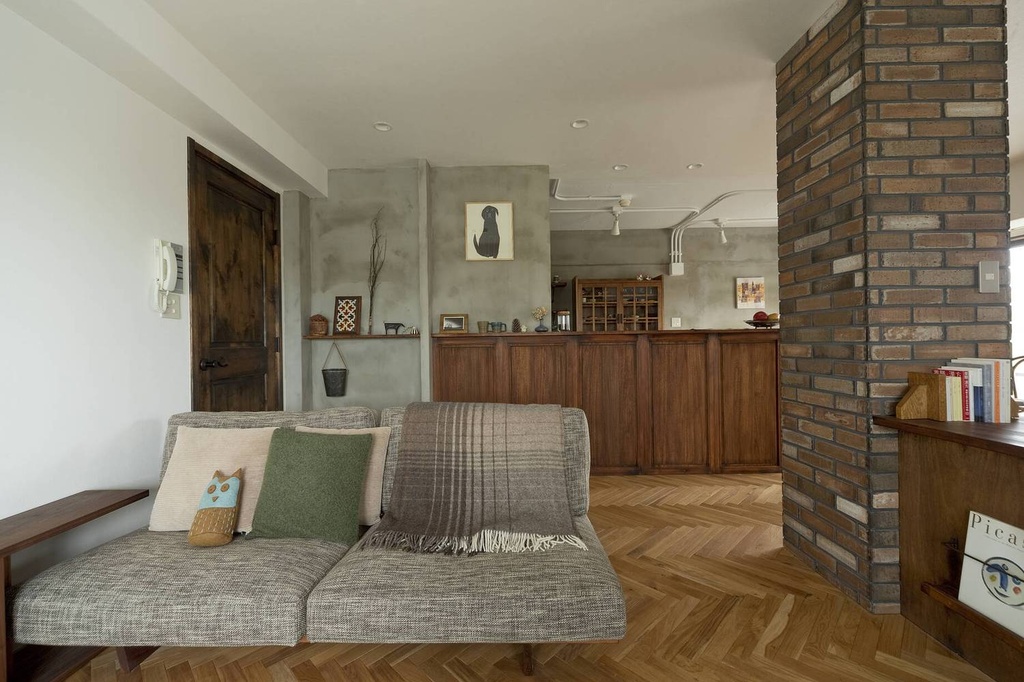 hacorenove style interior, modern Japanese kitchen-dining room, dark gray cabinets, warm plaster walls, arched doorway, wooden dining table, black mid-century chairs, recessed spotlights, sheer curtains, moody earthy tones