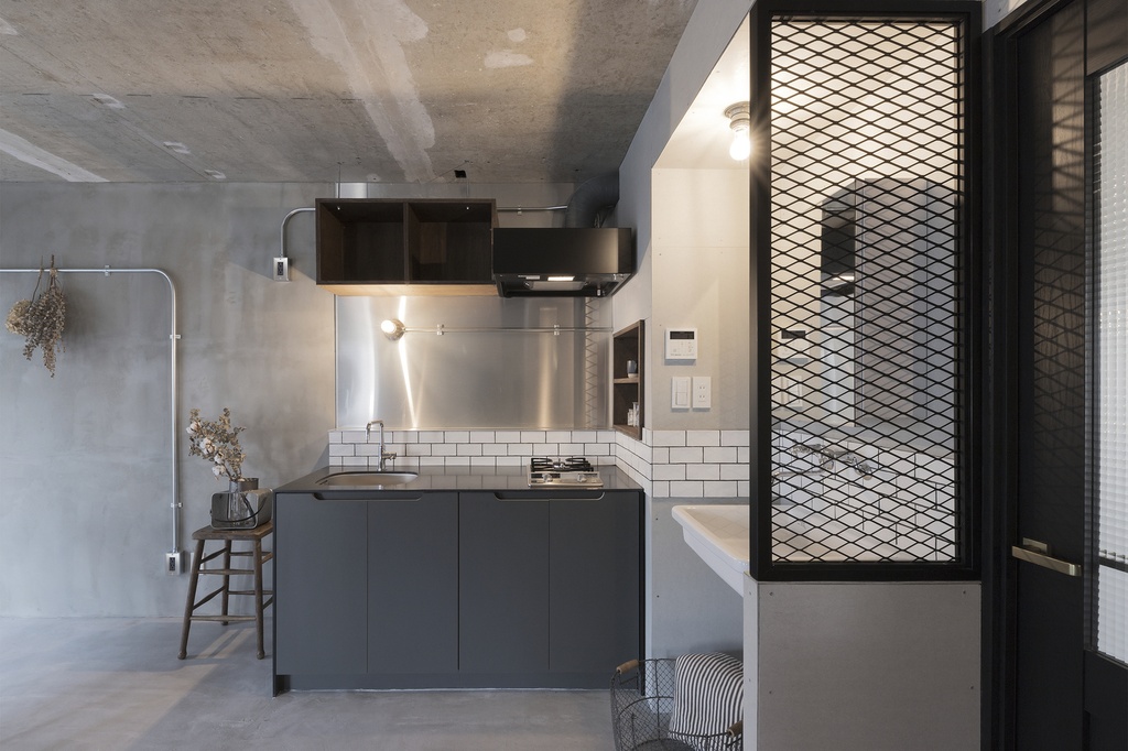 hacorenove style interior, industrial loft kitchen, exposed concrete ceiling, metal ductwork, terrazzo-style green backsplash, open wooden shelving, light oak flooring, hanging plants, warm lived-in atmosphere, natural light