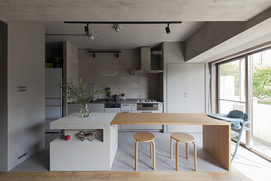 hacorenove style interior, open-plan kitchen-living space, exposed concrete ceiling, industrial ductwork, white cabinetry, oak wood flooring, rustic dining table, hanging greenery, pendant lights, warm natural light, Japanese industrial-bohemian atmosphere