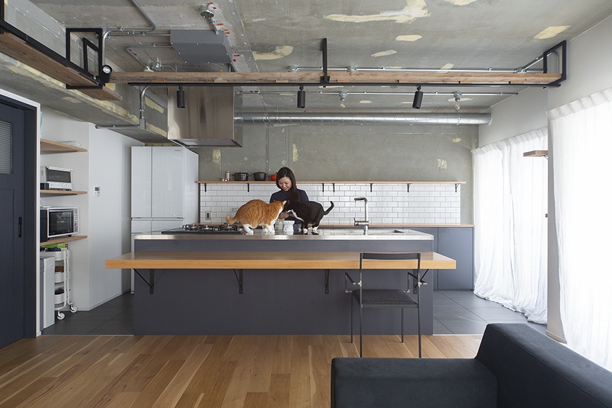 hacorenove style interior, industrial open kitchen, exposed concrete ceiling, black steel framework, white subway tile backsplash, gray island with wood counter, oak flooring, natural light, minimalist Japanese loft atmosphere