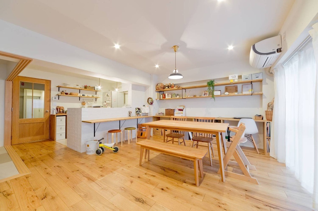 hacorenove style interior, open-plan Japanese living-dining-kitchen, natural oak hardwood floors, white walls, wooden dining table with bench, open shelving, recessed and pendant lighting, warm cozy family atmosphere