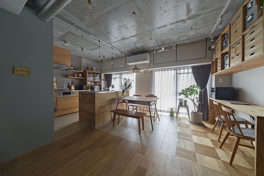 hacorenove style interior, open-plan kitchen-dining space, exposed concrete ceiling, natural oak wood cabinetry, herringbone flooring, subway tile backsplash, industrial pendant lighting, green plants, soft natural light, Japanese industrial-warm aesthetic