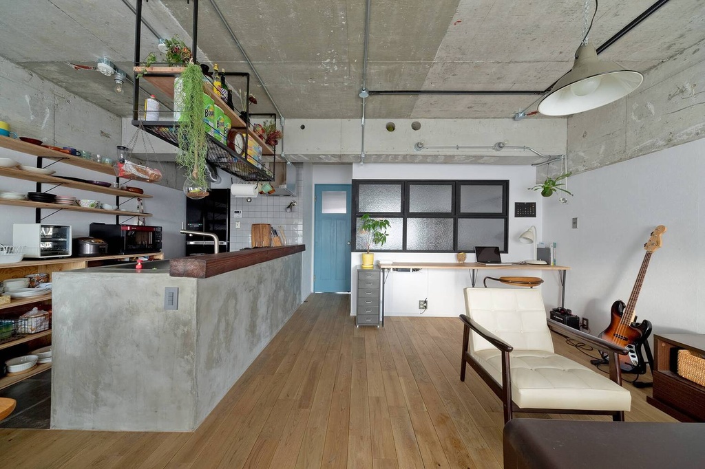 hacorenove style interior, industrial loft open-plan kitchen-living space, exposed concrete ceiling, oak hardwood floors, concrete kitchen counter, black steel shelving, hanging plants, turquoise accent door, natural daylight, relaxed atmosphere