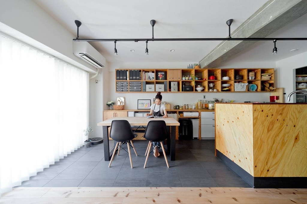 hacorenove style interior, Japanese industrial dining kitchen, exposed concrete beam, plywood island and open shelving, dark gray tile floor, black track lighting, white walls, natural daylight, minimalist warm atmosphere