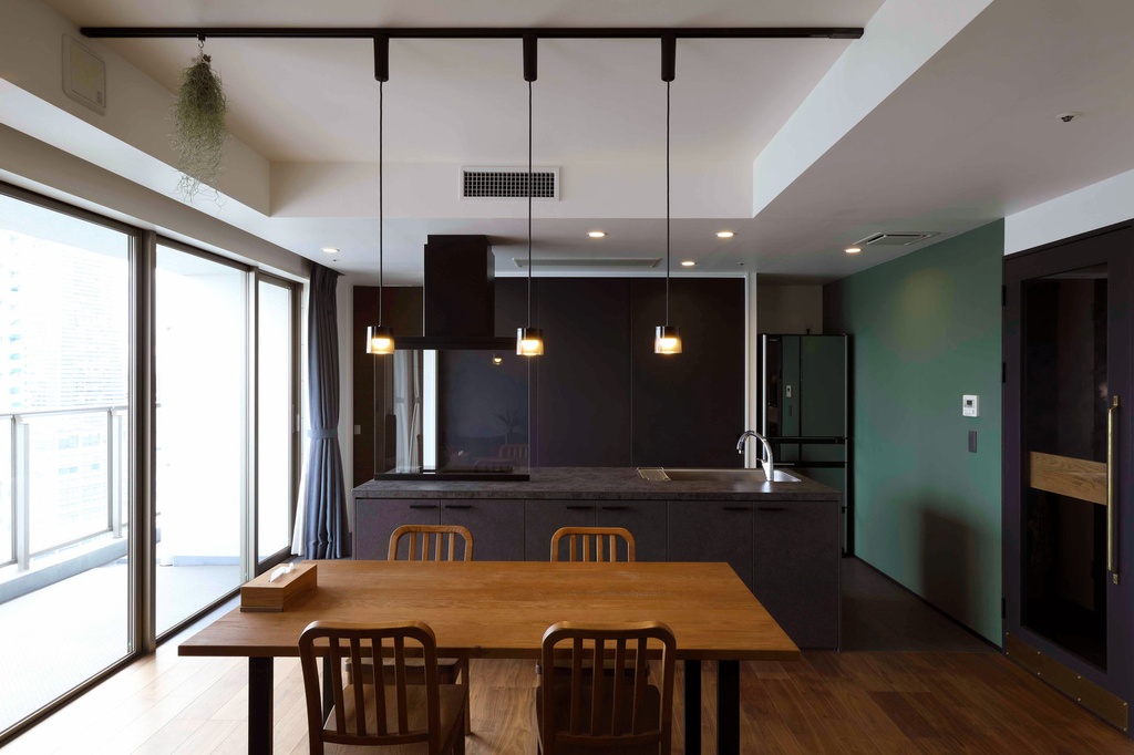 hacorenove style interior, modern open-plan kitchen dining room, dark charcoal island, oak dining table, wooden flooring, teal accent wall, pendant lights, floor-to-ceiling windows, natural daylight, minimalist Japanese aesthetic